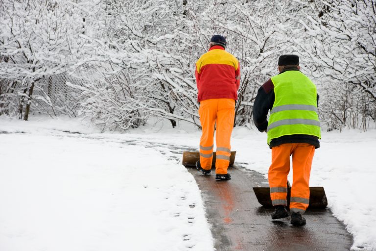 Workers removing first snow from pavement
